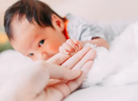 Parent doing tummy time with newborn, supporting newborn developmental milestones