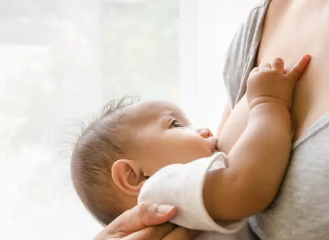 Mother breastfeeding newborn, showing guidance on positioning, attachment and breastfeeding support