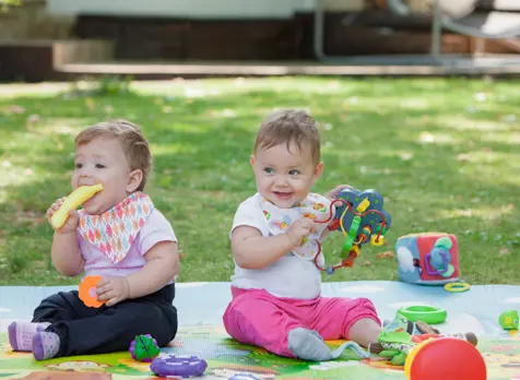 Two babies playing in childcare setting, supporting information on starting childcare