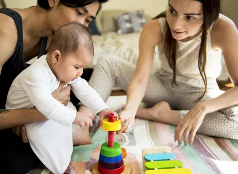 Parents working on baby milestones through play
