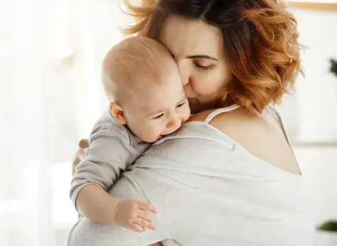 Crying baby being soothed by mum demonstrating calming techniques and understanding baby cues